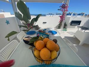 a bowl of oranges on a table on a balcony at Casa Blue Azul in Fuzeta