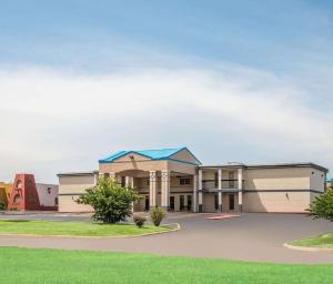 a large building with a blue roof at Hotel King Bed Hotel Room 120 Booking in Stillwater