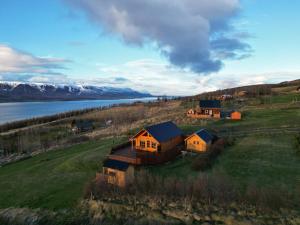 a house on a hill next to a body of water at Eys Cabin in Akureyri