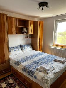 a bedroom with a large bed with a window at Pensiunea Colt de Rai, Vistisoara in Stațiunea Climaterică Sâmbăta