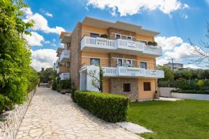 a large yellow building with white balconies at Aphrodite Apartments in Kalyves