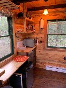a kitchen in a log cabin with two windows at Treehouse Ranch in Goldendale