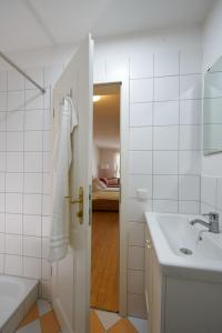 een witte badkamer met een wastafel en een spiegel bij SEEMOMENTE Überlingen an der Promenade in Überlingen
