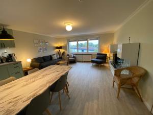 a kitchen and living room with a large wooden table at Casa Raphael direkt am Scharbeutzer Strand in Scharbeutz