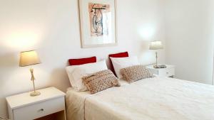 - une chambre avec un lit blanc et 2 tables de chevet dans l'établissement Quarteira Beach Vacation: 2BR steps to the sand, à Quarteira 27 autres photos