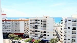 une vue aérienne de bâtiments avec l'océan en arrière-plan dans l'établissement Quarteira Beach Vacation: 2BR steps to the sand, à Quarteira