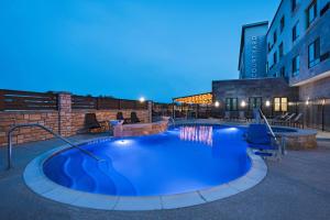 a large swimming pool in a building at night at Courtyard Dallas Grand Prairie in Grand Prairie
