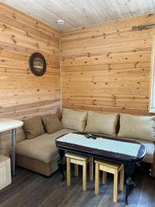 ein Wohnzimmer mit einem Sofa und einem Tisch in der Unterkunft Котедж бiля рiчки село Кудашiвка in Kudashevka