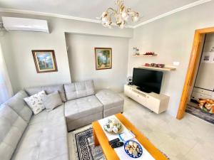 a living room with a couch and a tv at City Centre Big Art'partment Heart of The Capital in Tirana