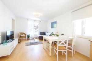a white living room with a table and a couch at SEEMOMENTE Überlingen Promenade in Überlingen