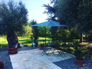 une terrasse avec une table et un parasol dans l'établissement QUIRICO GUEST HOUSE, à Locorotondo