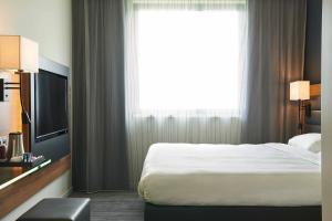 a hotel room with a bed and a large window at Moxy Ludwigshafen in Ludwigshafen am Rhein