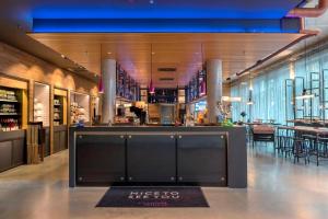 un ristorante con bar al centro di una stanza di Moxy Ludwigshafen a Ludwigshafen am Rhein