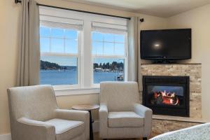 a living room with two chairs and a fireplace at Waterfront Inn in Gig Harbor