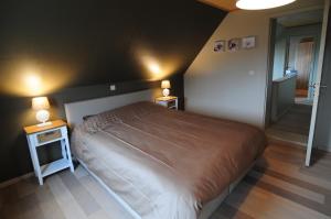 a bedroom with a large bed and two night stands at Holiday home De Levensgenieter in Torhout