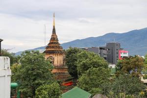 een pagode in een stad met bergen op de achtergrond bij Jeune Hostel Chiang Mai - Chang Phuak in Chiang Mai