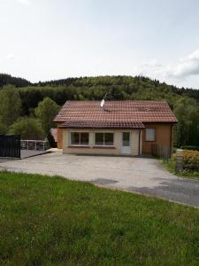 een klein huis met een rood dak op een oprit bij AIR PAIX LE MONT in Herpelmont