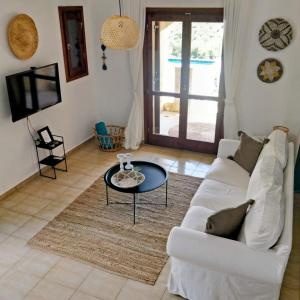 Country Bellavista Darmarohori في Darmarochori: غرفة معيشة مع أريكة بيضاء وطاولة