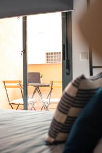 貝萊斯－馬拉加的住宿－Nordik Rooms Village - Chilches "Taby"，卧室配有1张床、1张桌子和1把椅子