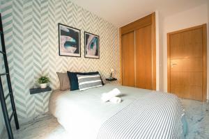 貝萊斯－馬拉加的住宿－Nordik Rooms Village - Chilches "Taby"，一间卧室配有一张床,上面有两条毛巾