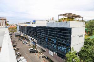 een uitzicht op een gebouw met een parkeerplaats bij Jeune Hostel Chiang Mai - Chang Phuak in Chiang Mai