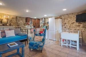 a living room with a couch and a kitchen at El Pajar de Tía María in Casas del Castañar