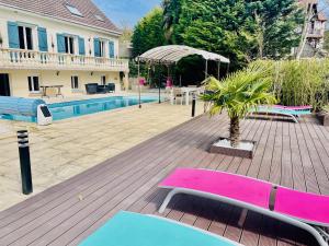taras z różową i niebieską ławką obok domu w obiekcie Appartement 120m2 dans maison avec piscine w mieście Boissy-lʼAillerie