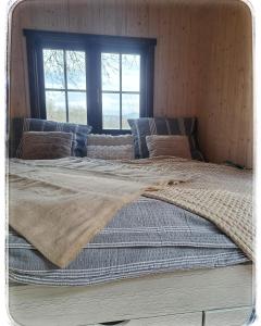 Una cama grande con una manta encima. en Maringotka Trutnov, en Trutnov