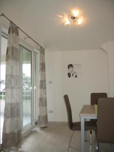 a dining room with a ceiling fan and a table and a window at Apartments Car in Šilo