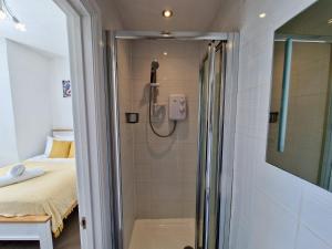 ein Bad mit Dusche und ein Bett in einem Zimmer in der Unterkunft Incredible Private Rooms All with Private Bathrooms in a Fully Serviced House next to City Centre with Free Parking in Coventry