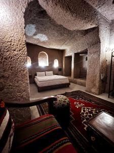 a room with a bed and a couch in a stone room at Grand Uchisar Hotel in Uçhisar