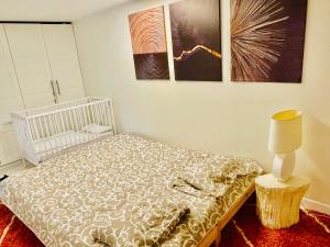 Un dormitorio con una cama y una lámpara. en Appartement 120m2 dans maison avec piscine en Boissy-lʼAillerie