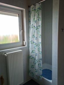 a shower curtain in a bathroom with a window at Balaton White House in Vonyarcvashegy