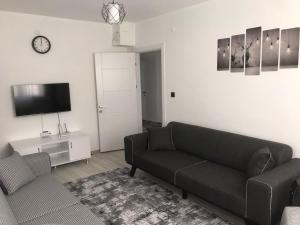 a living room with a couch and a tv at Backyard Apart in Kemer