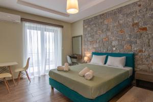 a bedroom with a large bed and a brick wall at Verga's Apartments in Kalamata