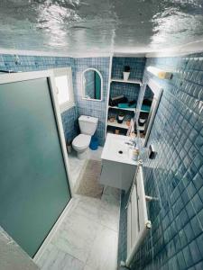La salle de bains est pourvue de carrelage bleu, d'un lavabo et de toilettes. dans l'établissement The Blue Sea View Sidi Bou Said, à Sidi Bou Saïd