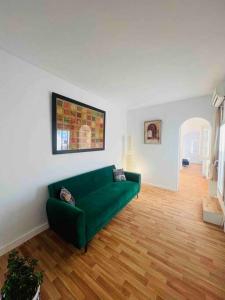 uma sala de estar com um sofá verde e pisos em madeira em The Blue Sea View Sidi Bou Said em Sidi Bou Saïd