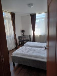 a bedroom with a bed and a table and a window at Vila Oltețul in Predeal