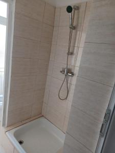 a shower with a glass door next to a tub at Vila Oltețul in Predeal