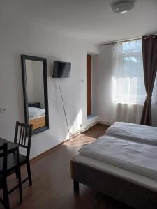 Schlafzimmer mit einem Bett, einem Spiegel und einem Tisch in der Unterkunft Vila Oltețul in Predeal