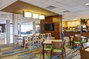 a dining room with tables and chairs and a tv at Fairfield Inn & Suites by Marriott Rochester Mayo Clinic Area/Saint Marys in Rochester