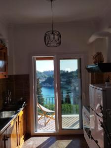 een keuken met een glazen schuifdeur met uitzicht bij Teo & Niki in Paleokastritsa