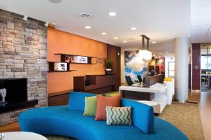 a living room with a blue couch and a fireplace at Fairfield Inn & Suites by Marriott Rochester Mayo Clinic Area/Saint Marys in Rochester