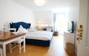a living room with a bed and a desk and a room with a bed at SEEMOMENTE Überlingen Promenade in Überlingen