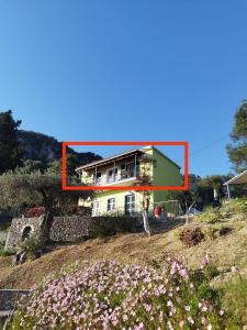een huis bovenop een heuvel met bloemen bij Teo & Niki in Paleokastritsa