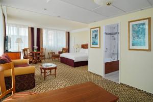 een hotelkamer met een bed en een woonkamer bij Leipzig Marriott Hotel in Leipzig