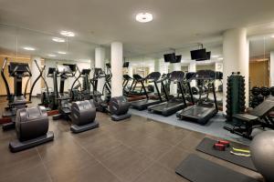 a gym with several treadmills and machines in it at Leipzig Marriott Hotel in Leipzig
