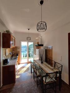 a kitchen with a table with chairs and a window at Teo & Niki in Paleokastritsa