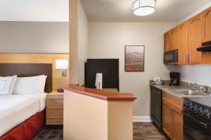 a hotel room with a bed and a kitchen at TownePlace Suites by Marriott Denver Downtown in Denver