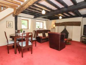 a living room with a table and chairs and a couch at Nant Coed Annex in Abergele